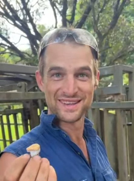 Australian cowboy holding a set of PureBuds Pro Earbuds