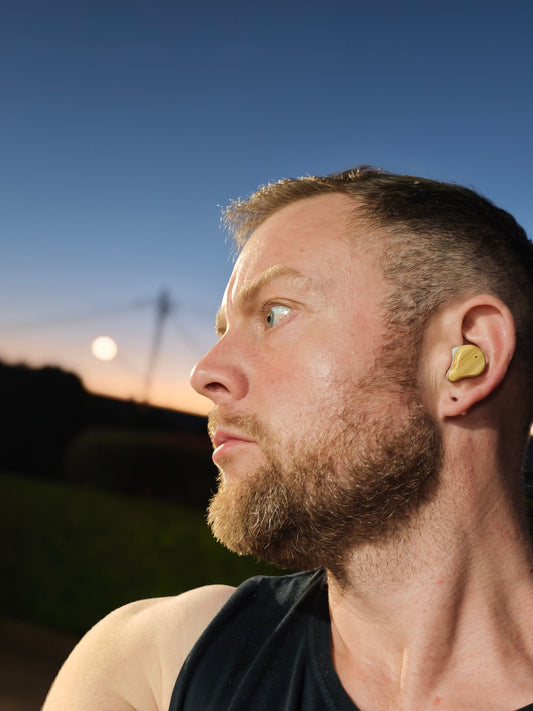 Man in singlet wearing bamboo earbuds
