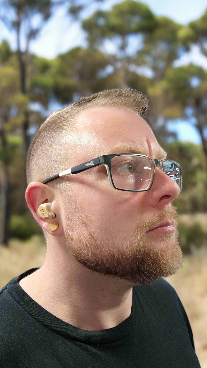 Man wearing bamboo earbuds in the outback 