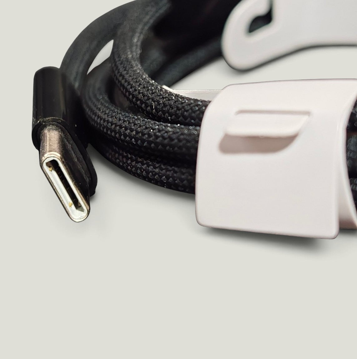 We Pure black braided nylon USB-C to USB-C cable with a laser-engraved connector and white cable tie.