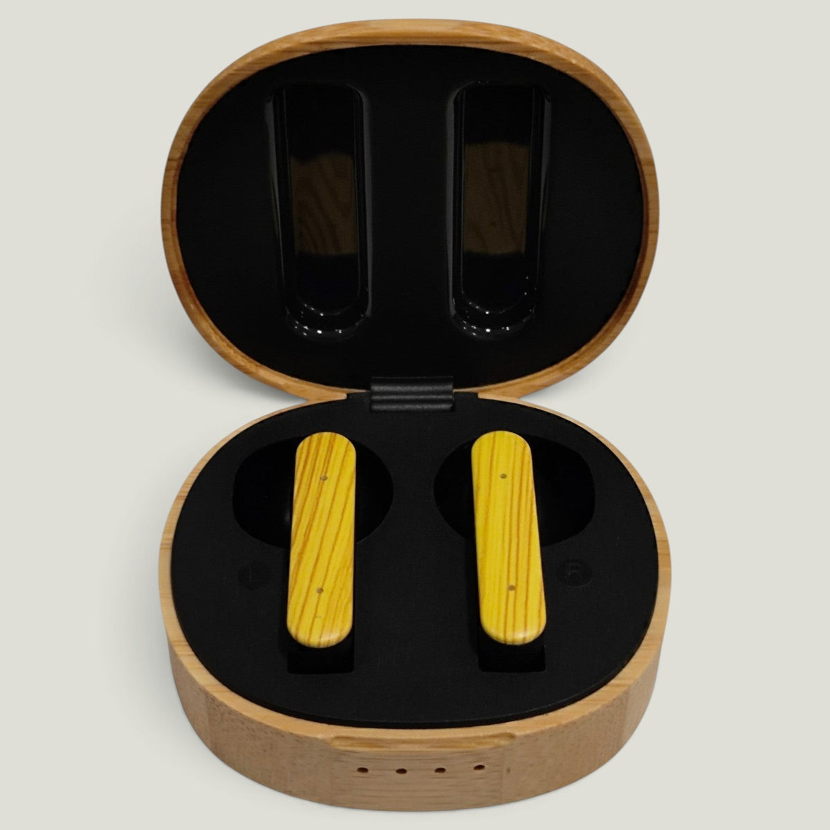 We Pure PurePods open-fit earbuds with yellow wood-grain finish inside a round bamboo charging case.