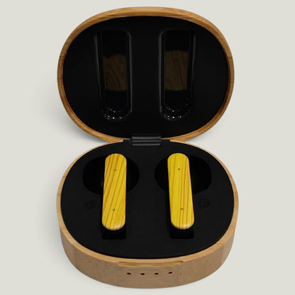We Pure PurePods open-fit earbuds with yellow wood-grain finish inside a round bamboo charging case.