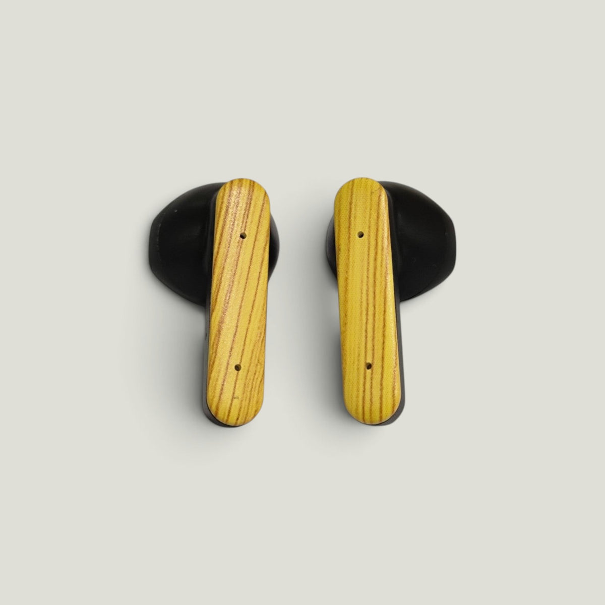 We Pure PurePods open-fit earbuds featuring a black recycled plastic body and a distinctive wood grain faceplate.